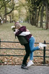 A couple embraces warmly in a park, celebrating their love on Hug Day amidst nature's beauty.