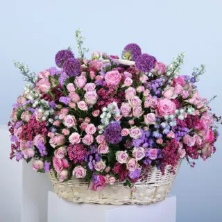 A grand, luxurious basket overflowing with roses and pastel blooms.