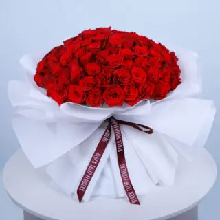 Valentines Day Home 69 Bouquet of 101 red roses tied elegantly arranged in white wrap and tied with maroon ribbon.