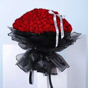 A vibrant bouquet of red roses elegantly arranged on a pristine white table, showcasing their beauty and freshness.