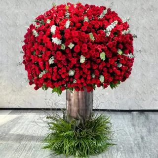 A large tree-shaped arrangement of 1000 red roses in a vase.