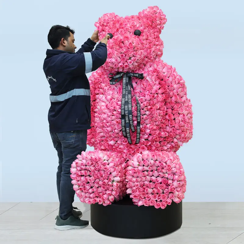 rose-teddy-bear A large teddy bear arrangement made of baby pink roses tied with a black ribbon.
