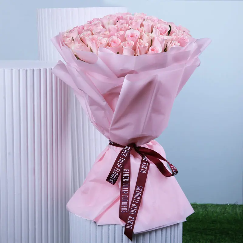 pink-rose-bouquet A charming bouquet of pink roses in delicate pink wrapping, finished with a maroon ribbon.