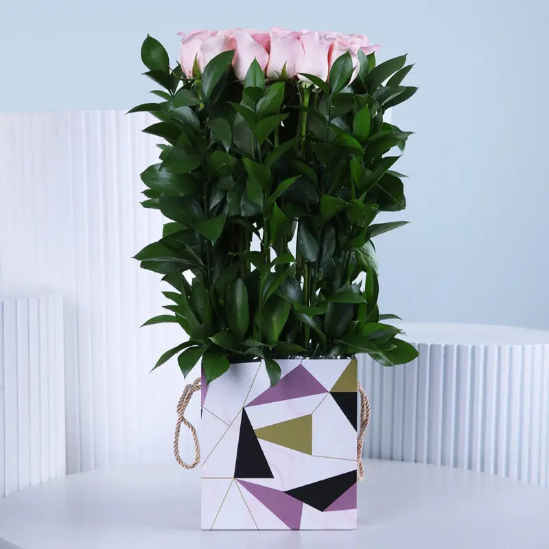 blush-boxed-pink-roses A luxurious pink rose bouquet in a modern designer box with lush green foliage—an elegant floral gift for Women's Day.