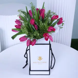 A charming purple tulip box, wrapped in white in a luxurious gift box.