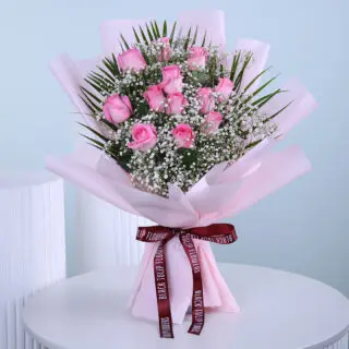 A stunning bouquet of fresh pink roses, elegantly wrapped with baby’s breath and greenery, perfect for any special occasion.