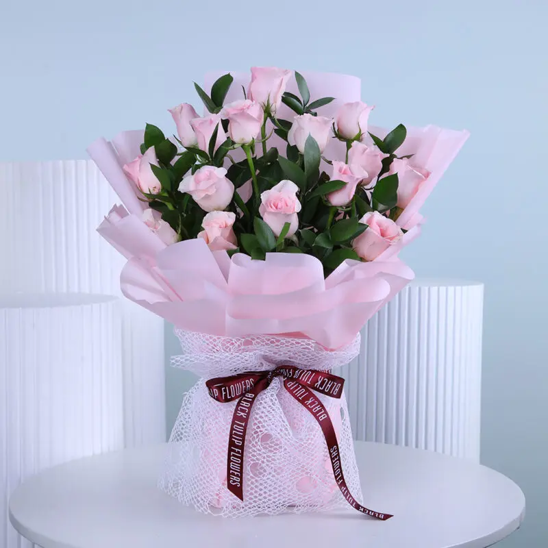 sweet-pink-roses Light pink roses bouquet, elegantly wrapped in pink and tied with maroon ribbon.