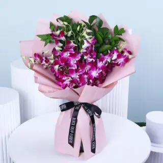 Bouquet of purple orchids in pink wrap