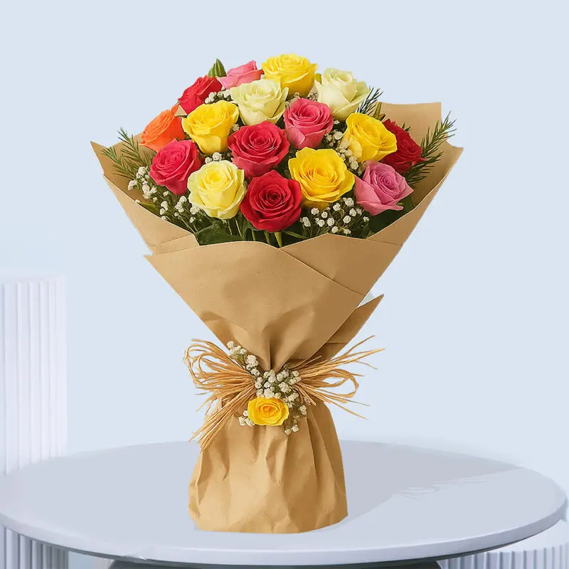15-Vibrant Mixed Rose Bouquet A vibrant bouquet of mixed garden roses in shades of red, yellow, pink, and orange with white baby's breath and green foliage, wrapped in brown paper and tied with a raffia bow and a small yellow rose.