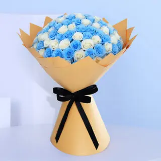 A large bouquet filled with alternating layers of vibrant blue roses and pure white roses, creating a striking two-tone effect in light brown wrap and tied with a black ribbon.