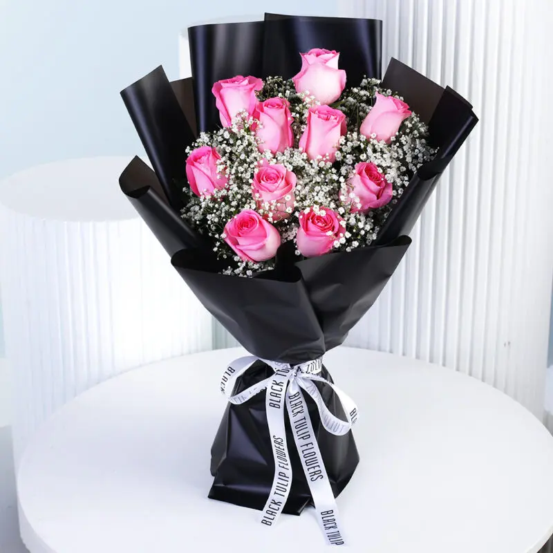pink-rose-gypso-bouquet A charming arrangement of pink roses and white gypsophila, elegantly wrapped in black and finished with a crisp white ribbon.