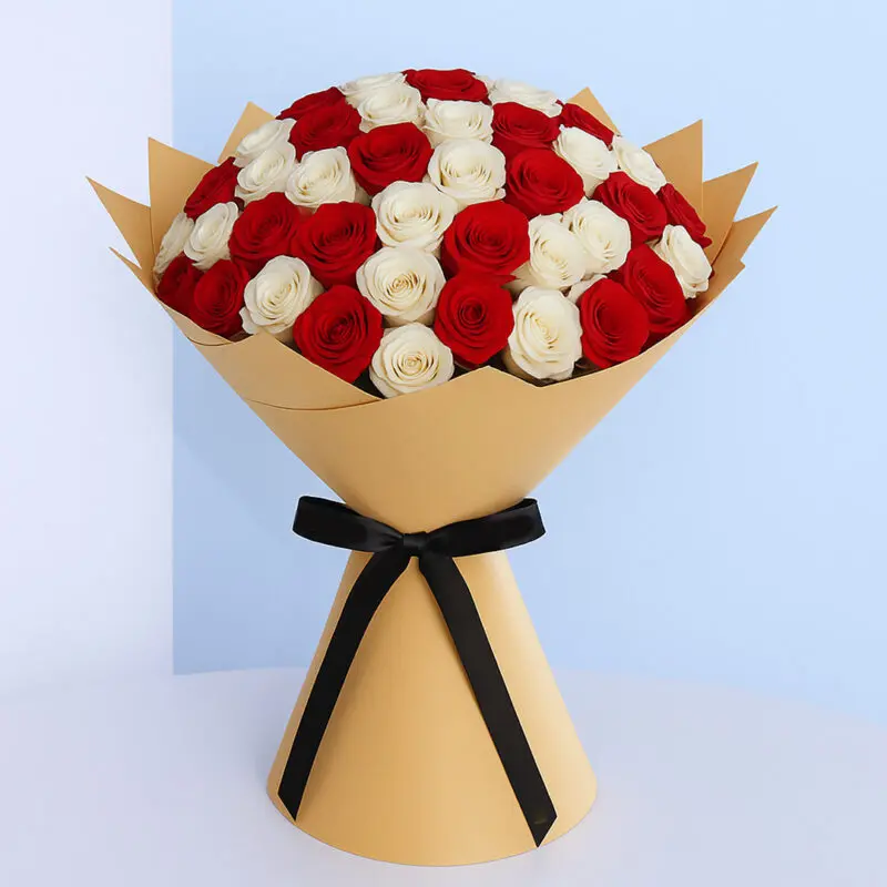 red-white-rose-bouquet Freshly cut red and white roses arranged in a hand-tied bouquet, wrapped with brown and a contrasting black ribbon.