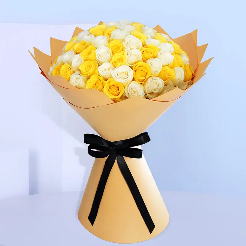yellow-white-rose-bouquet Bouquet of fresh white and yellow roses wrapped in golden brown and tied with a black ribbon.