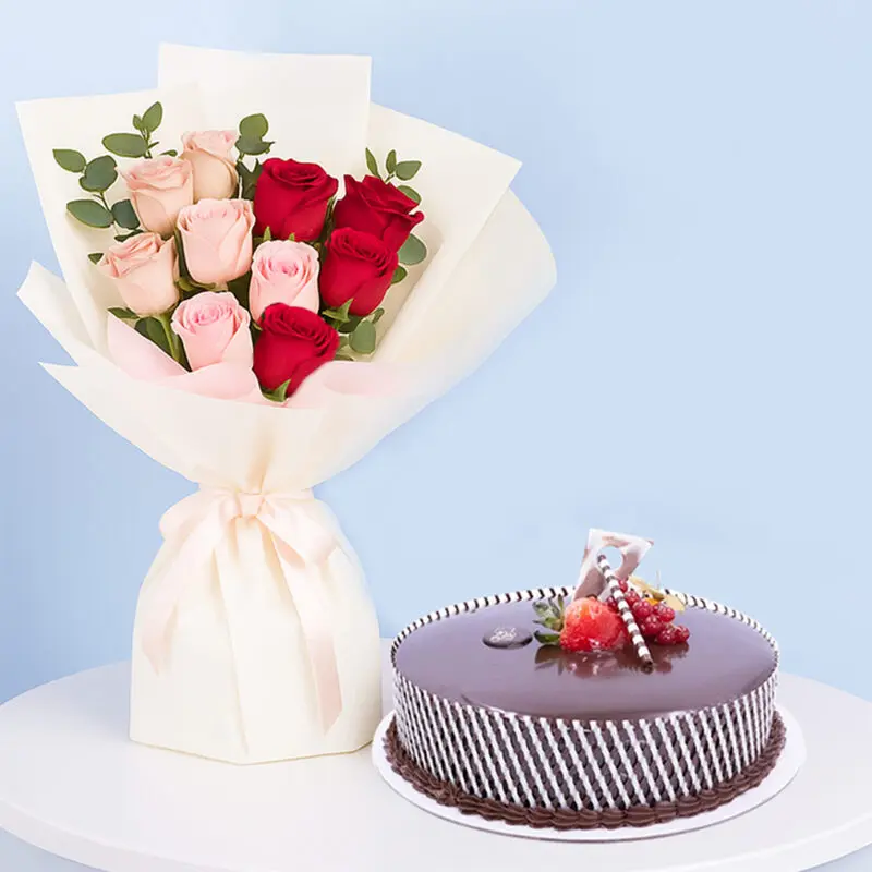 Pink-red-rose-cake-combo-01 A celebration combo featuring a bouquet of red and pink roses, a round chocolate cake with white stripes and strawberries on top..
