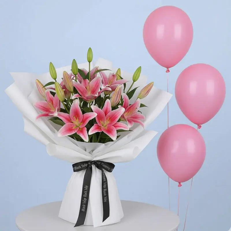 pink-lilies-pink-balloons-01 A vibrant pink lily bouquet with multiple blooming lilies and green buds, wrapped in white with a black branded ribbon and three pink balloons.