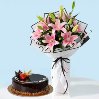 A combo gift set featuring a bouquet of pink lilies wrapped in black and white with a black ribbon. A glossy chocolate truffle cake garnished with a fresh strawberry and a physalis berry.