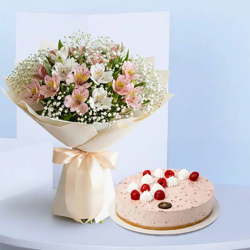 white-pink-alstroemeria-cake-01 A pink and white alstroemeria flower bouquet with baby's breath, tied with a light pink ribbon and a round raspberry cheesecake topped with fresh raspberries and white whipped cream.