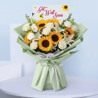A bouquet with sunflowers, white roses, and lilies in mint green wrapping, tied with a satin ribbon and a cheerful " Get Well Soon" card.
