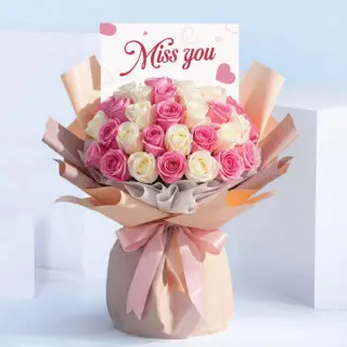 Miss You bouquet featuring pink and white roses hand-tied in blush wrapping with a satin ribbon and “Miss You” card.