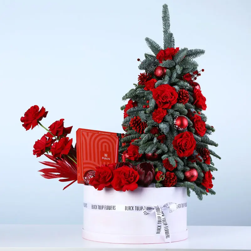 christmas-patchi-flower-hamper Christmas flower hamper with mini Christmas tree arrangement, red roses, Nobilis leaves, ornaments, and a Patchi 470g chocolate box.