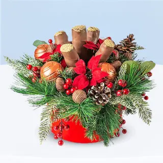 Festive chocolate and cake pop gift box decorated with greenery, red berries, pinecones, and edible chocolate ornament.