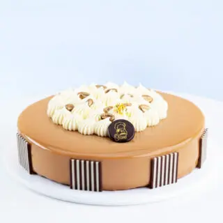 Mocha Bean Cake 1 Kg by Mister Baker topped with cream swirls and chocolate decorations
