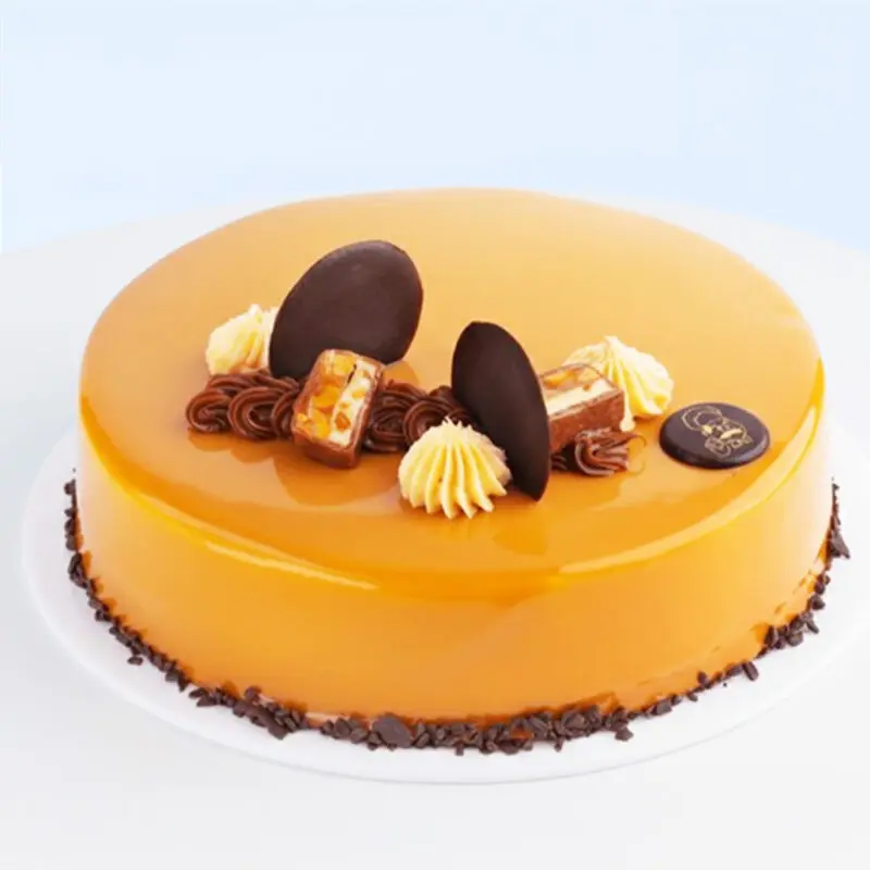 snickers-cake Snickers Cake 1 Kg by Mister Baker topped with frosting, chocolate pieces, and salted caramel glaze