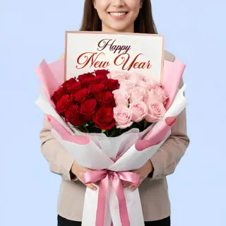 Red and blush pink rose bouquet with Happy New Year greeting card wrapped in pastel paper