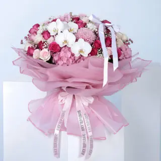 A bouquet featuring pink hydrangea, roses, gypsophila, and mixed flowers in premium pink wrapping with a satin bow.