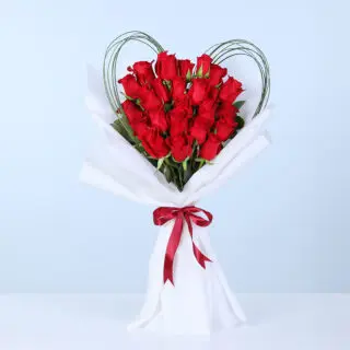 20 red roses arranged in a heart-inspired outline with loop accents in white wrapping, finished with a red ribbon.