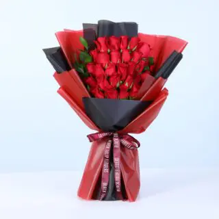 A bouquet of 25 red roses with ruscus greenery in red and black wrap.