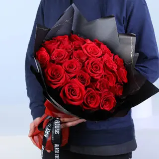 Bouquet featuring 25 red roses in premium black wrapping, finished with a black ribbon.