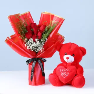 Valentines Day Home 50 A bouquet of seven red roses with greenery and a red teddy bear, perfect for expressing love and affection.