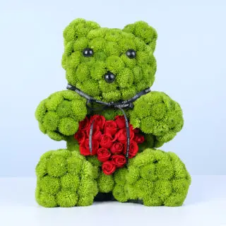 Green chrysanthemums and red spray roses styled as a flower teddy with a heart detail, finished with a ribbon.