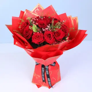 Valentines Day Home 40 A bouquet of red roses, baby’s breath and green fillers in a red Valentine heart wrapping.