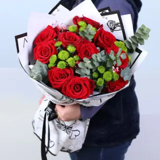 Red roses with green button chrysanthemums and eucalyptus in designer wrap