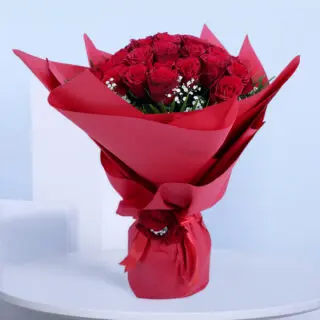 30 red roses with gypsophila and palm leaves in red wrap tied with a red ribbon.