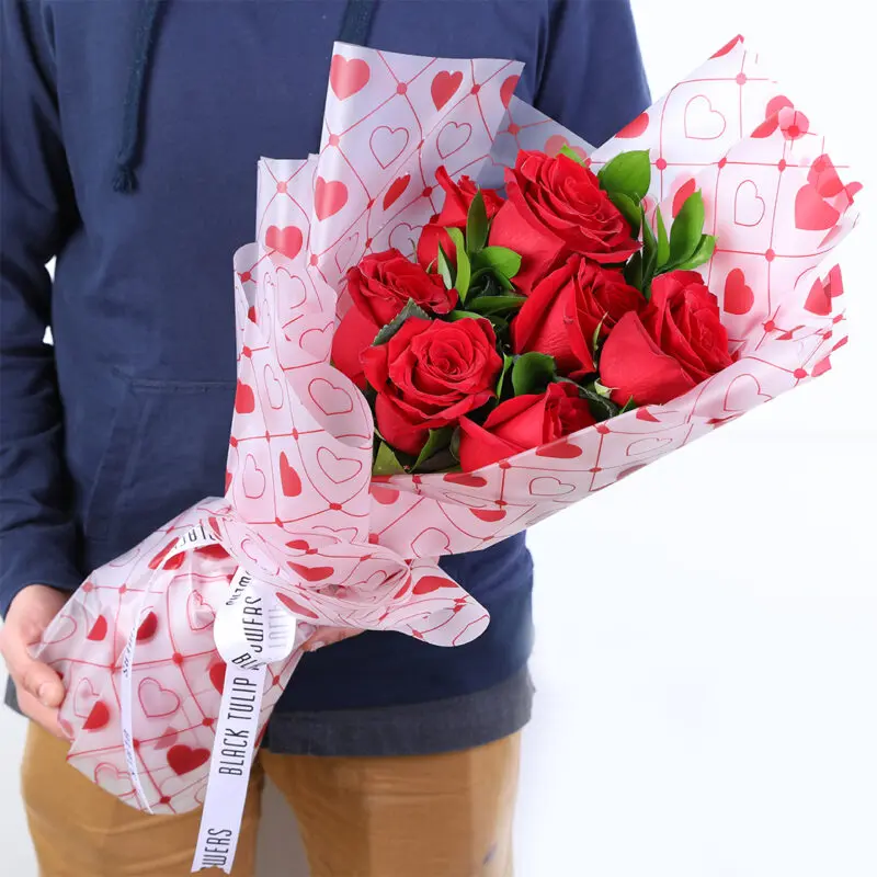 red-roses-heart-wrap-bouquet Red roses bouquet with heart-print wrapping tied finished with a white ribbon.