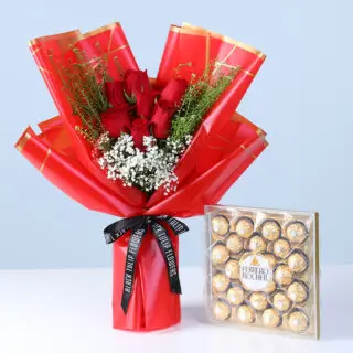 Valentines Day Home 49 Bouquet of red roses with white filler flowers and green foliage in pink wrapping, with a Ferrero Rocher chocolate box.