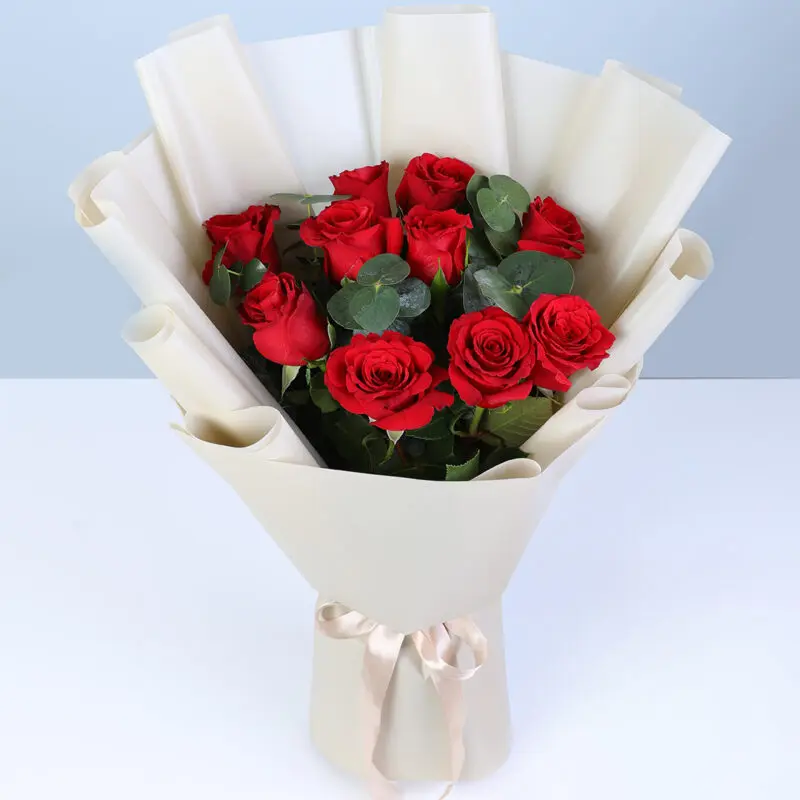 signature-red-roses-eucalyptus-bouquet A bouquet of red roses and eucalyptus accents, elegantly wrapped and finished with a satin ribbon.