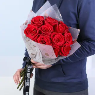 Bouquet with 15 red roses wrapped in heart-print paper and premium ribbon.