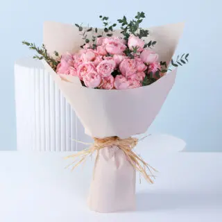 Blush pink garden roses with greenery in nude wrapping, finished with ribbon detailing.