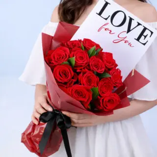 Valentines Day Home 15 Bouquet featuring red roses with green leaf accents in premium red wrapping, finished with a LOVE message card.
