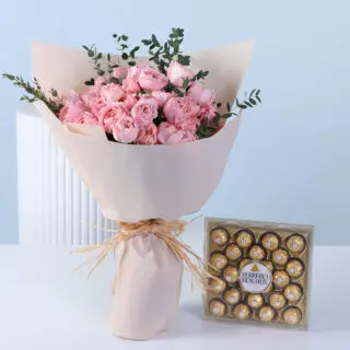 Bouquet of pink spray roses with greenery in nude wrapping, finished with ribbon and paired with a 24-piece Ferrero Rocher chocolate box.