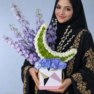 Purple flowers, green-and-white crescent blooms and blue hydrangea in a modern gift box arrangement,