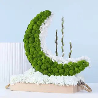 Ramadan crescent moon floral table centerpiece featuring green button chrysanthemums, white flowers, and hydrangeas arranged on a wooden base.