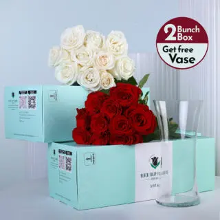 Red roses and white roses bunches in a green box with vase.