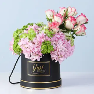 Graceful pastel floral arrangement presented in a luxury black display box