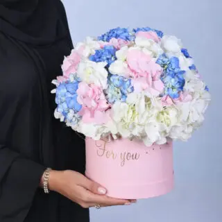 Rounded hydrangea cluster in blended soft colours, beautifully presented in a modern pink floral box