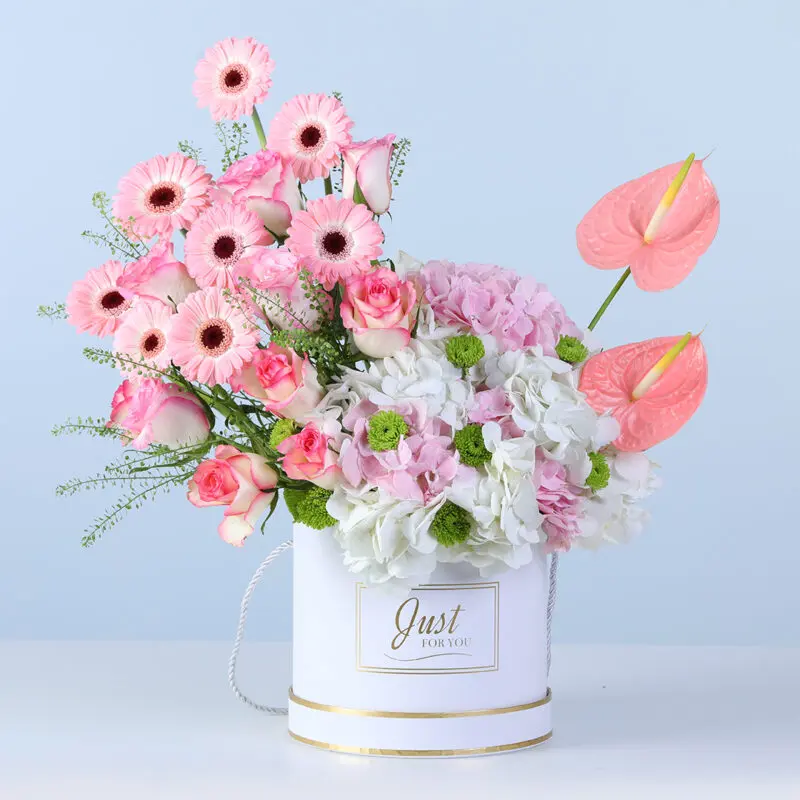pastel-mixed-floral-arrangement-white-box A soft pastel floral arrangement with layered blooms and fresh green accents, beautifully styled in a round white box.
